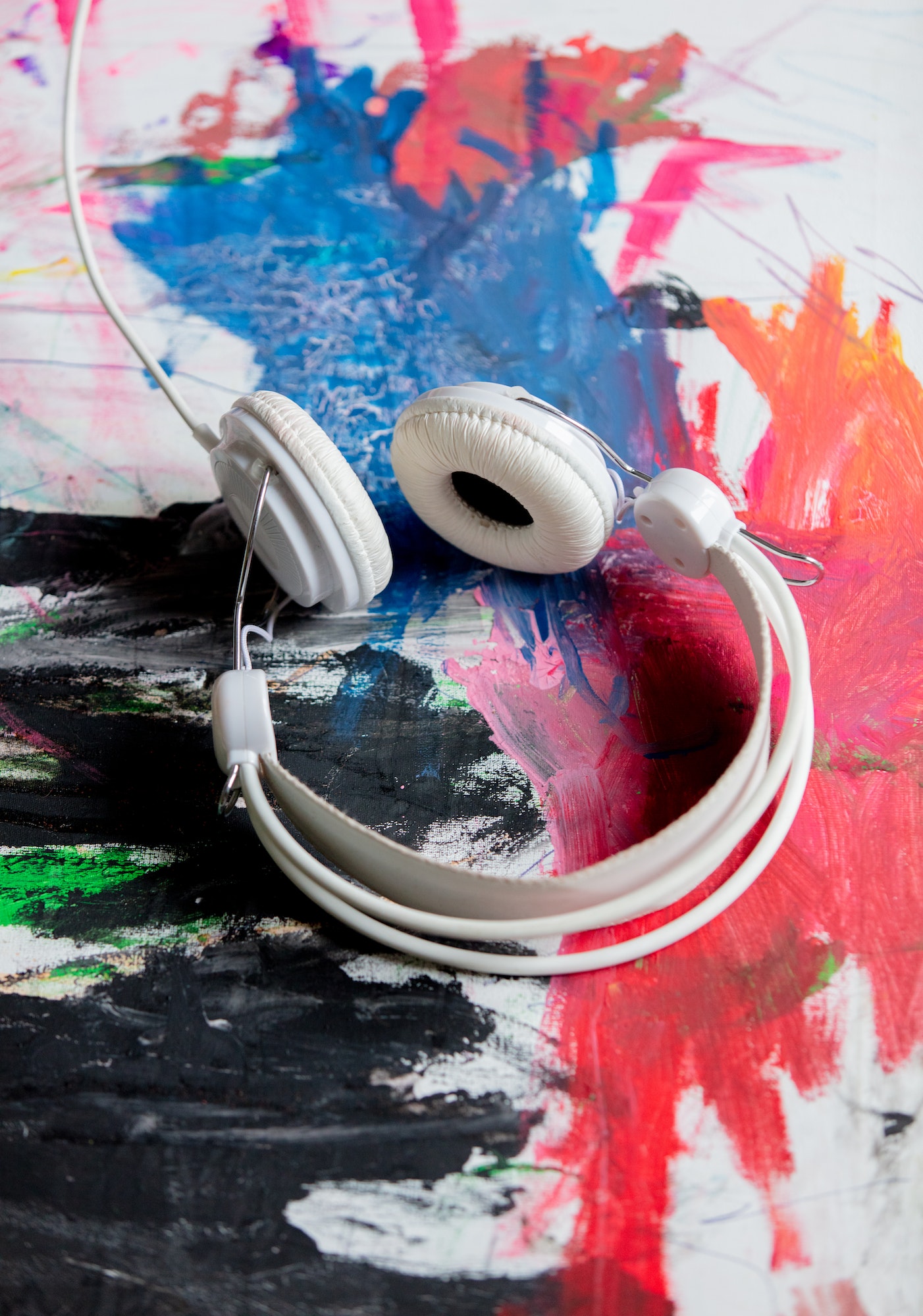 Classic cable headphones on art paint. Above view